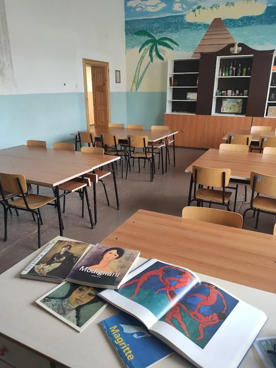 Arbeitsbereich mit Büchern und Bildern im Klassenzimmer — aus der Welt von Jasmina und PAGANE