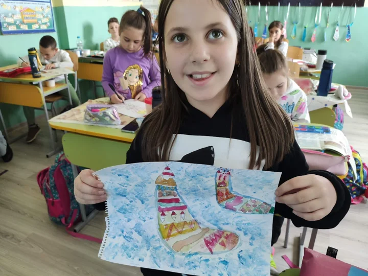 Ein Kind zeigt seine Zeichnung im Klassenzimmer — aus der Welt von Jasmina und PAGANE