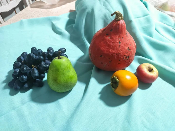 Auf einem bunten Tuch angeordnetes Obst — aus der Welt von Jasmina und PAGANE